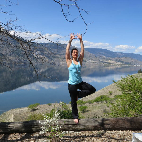 Yoga pose with the lake and mountains in the background.