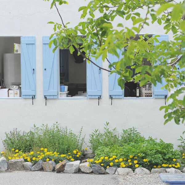 Look into the outdoor kitchen through open windows.