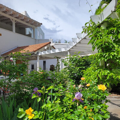View of the front entrance and with the flowers growing in the front yard.