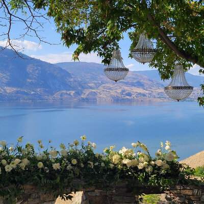 View over Skaha lake from the house with three chandeliers hanging from a tree